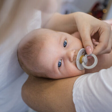 Newborn,In,The,Arms,Of,Caring,Parents.,He,Is,Soothed